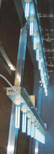 Typical commercial installation of two 10-probe Air Probe Sanitizers. The UV-C probes are illuminating the large evaporator coil behind them.